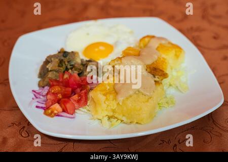 Une assiette vibrante et colorée de cuisine traditionnelle avec des œufs, des légumes frais et de délicieuses sauces salées Banque D'Images