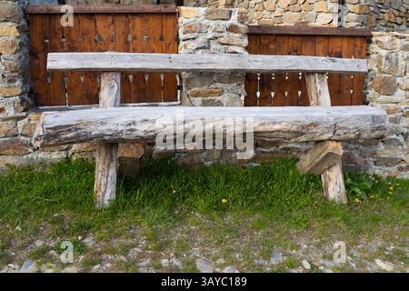 Ancien banc traditionnel en bois devant une clôture en pierre et en bois à la campagne Banque D'Images