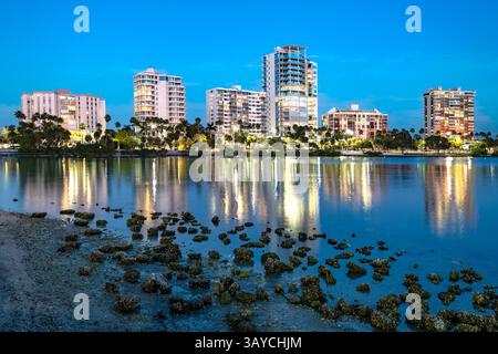 Vue panoramique de la ligne d'horizon de Sarasota avec des immeubles d'appartements illuminés reflétant sur les eaux tranquilles pendant le crépuscule en Floride, États-Unis. Banque D'Images
