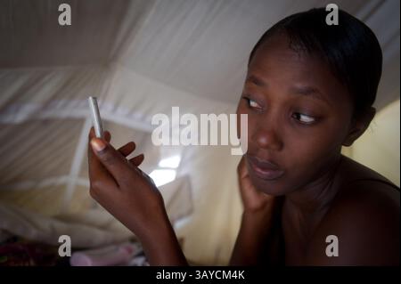 Juin 28, 2010 - Port au Prince, Haïti - Anide FLEUREME, 24 ans, est une écolière qui tente d'obtenir son diplôme de 12e année à l'École Centre Educatif-Luis Josephe Jamlien. Elle était à l'école pendant le tremblement de terre mais a réussi à s'échapper. L'école est maintenant rouverte sous une tente à quelques lots de l'emplacement du bâtiment fissuré d'origine. Anides dit aime la comptabilité et espère qu'à la fin de ses études secondaires, elle pourrait aller à l'université, mais elle dit : « le pays est brisé en ce moment donc je ne sais pas ce qui va se passer. » Elle vit avec ses 2 cousines, 3 nièces et un neveu dans une tente dans un camp du Delm Banque D'Images