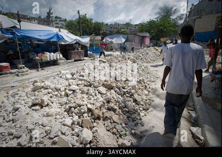 01 juil. 2010 - Port au Prince, Haïti - MIRTO PIERRE marche parmi les décombres dans les rues du quartier Delmas 30 où il vivait avec sa famille avant que leur maison et leurs vies soient détruites par le tremblement de terre. Maintenant, il reste avec sa fille blessée Mirlanda à l'hôpital de campagne MSF (Medicine sans frontières) Port au Prince, Haïti. Ils partagent un lit d'hôpital. Sa femme et ses autres enfants se sont enfuis à la campagne. (Crédit image : © Jessica Brandi Lifland/ZUMApress.com) Banque D'Images