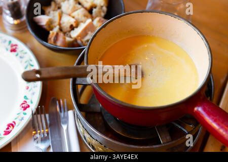 Variante française de fondue, fondue Savoyarde, préparation sur table Banque D'Images