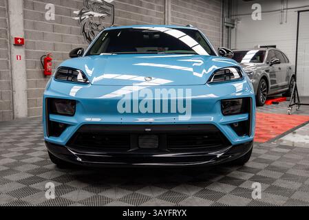 Gros plan vue de face d'une Porsche Macan bleue dans la salle d'exposition intérieure Banque D'Images