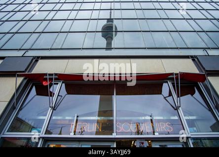 Tour de télévision de Berlin reflétée dans le verre d’une boutique de souvenirs à Alexanderplatz, avec une enseigne au néon indiquant « Berlin souvenirs », Allemagne. Banque D'Images