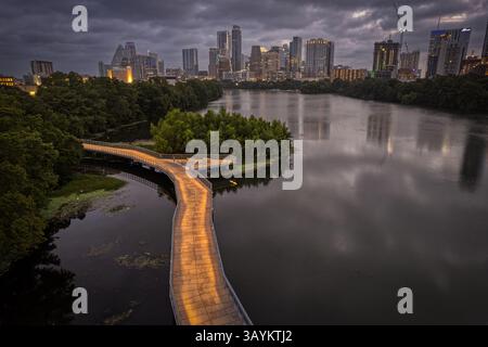 La ligne d'horizon d'Austin, Texas avec Lady Bird Lake et la promenade de randonnée et de piste cyclable au premier plan comme vu avant le lever du soleil le dimanche 16 juillet 202 Banque D'Images