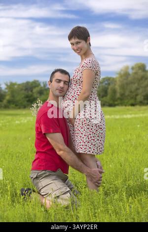 Mari s'occuper de sa femme enceinte sur les vertes prairies Banque D'Images