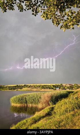 Formation massive de tempête avec des éclairs dans le ciel au-dessus d'un paysage de campagne. Orage après de fortes pluies. Météo estivale extrême avec dramatique Banque D'Images