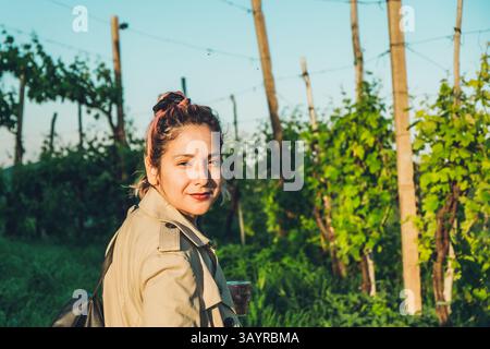 Gros plan portrait de la femme hispanique latino millénaire avec une robe élégante dans un vignoble à la campagne. Jeune femme confiante Banque D'Images