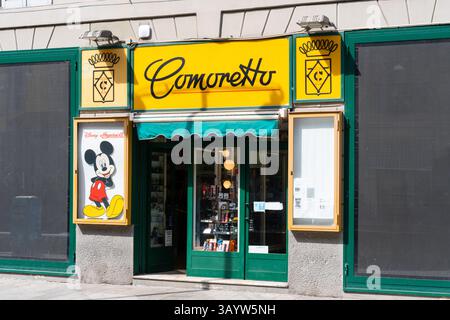 Milan, Italie - 12 avril 2025 : vitrine Comoretto à Milan avec signalisation jaune, affiche Mickey Mouse vintage et vitrine de montres Banque D'Images