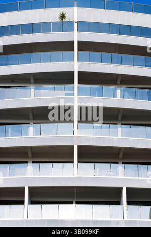 Façade urbaine symétrique avec balcons courbes et plante unique Banque D'Images