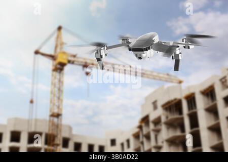 Drone avec caméra volant près d'un bâtiment inachevé. Véhicule aérien sans pilote pour la surveillance Banque D'Images