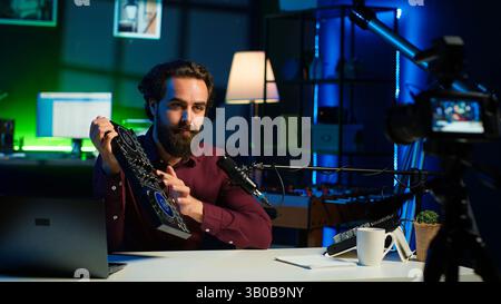 Examen de la technologie de tournage de l'homme, recommandant le contrôleur DJ nouvellement lancé. Influenceur préconisant un dispositif mélangeur de son de haute qualité devant les followers après l'avoir testé, caméra A. Banque D'Images