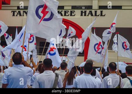 Singapour 2025 avr 23 - les partisans du PAP se sont vêtus de drapeaux du parti en vague blanche devant l'école de Chongfu le jour de la nomination lors des élections générales de Singapour Banque D'Images