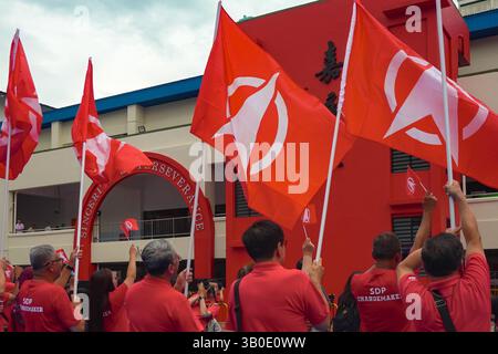 Singapour 2025 avr. 23 - les partisans du SDP se sont vêtus de drapeaux du parti en vague rouge devant l’école de Chongfu le jour de la nomination lors des élections générales de Singapour pour le non Banque D'Images