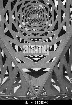 gros plan noir et blanc de sculpture en métal extérieur finement découpée de formes géométriques à l'infini avec des ombres du soleil un monochro vertical Banque D'Images