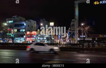 Busan, Corée du Sud - 19 mars 2018 : vue nocturne urbaine avec panneaux lumineux vibrants et véhicules en mouvement dans une rue animée Banque D'Images