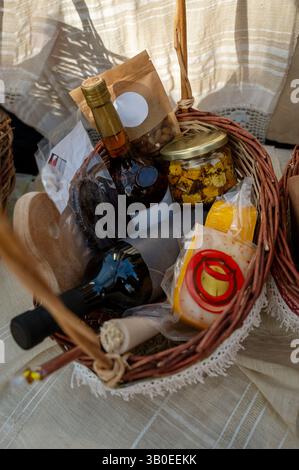 Panier en osier avec une bouteille de vin et coffrets cadeaux sur la table Banque D'Images