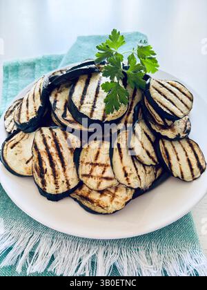 Aubergines grillées sur une assiette blanche. Nourriture saine et végétarienne. Directement au-dessus. Banque D'Images