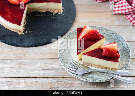 Tranche de cheesecake aux fraises sur une table en bois Banque D'Images