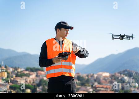 Homme professionnel en uniforme pilotant Drone à l'extérieur Banque D'Images