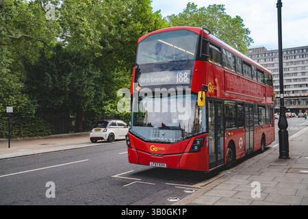 Londres, Angleterre, 11 juillet 2023, le bus à impériale rouge n° 188 en direction de North Greenwich s'arrête sur une rue calme encadrée par des arbres et un mélange de and moderne Banque D'Images
