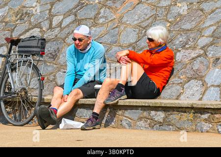 Exmouth, Devon, Royaume-Uni. 24 avril 2025. Météo britannique : cyclistes assis sur le front de mer profitant du soleil chaud de la station balnéaire d'Exmouth dans le Devon. Crédit photo : Graham Hunt/Alamy Live News Banque D'Images