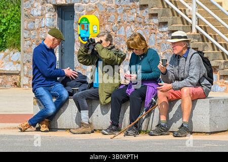 Exmouth, Devon, Royaume-Uni. 24 avril 2025. Météo britannique : promeneurs assis sur le front de mer profitant du soleil chaud à la station balnéaire d'Exmouth dans le Devon. Crédit photo : Graham Hunt/Alamy Live News Banque D'Images