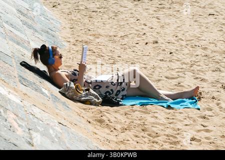 Exmouth, Devon, Royaume-Uni. 24 avril 2025. Météo britannique : un solarium sur la plage profitant du soleil chaud à la station balnéaire d'Exmouth dans le Devon. Crédit photo : Graham Hunt/Alamy Live News Banque D'Images