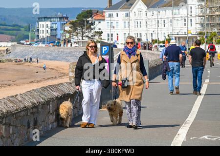 Exmouth, Devon, Royaume-Uni. 24 avril 2025. Météo britannique : promeneurs sur le front de mer profitant du soleil chaud à la station balnéaire d'Exmouth dans le Devon. Crédit photo : Graham Hunt/Alamy Live News Banque D'Images