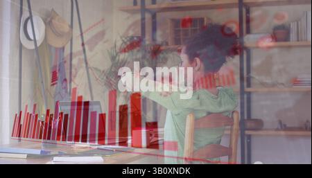 Image de cellules virales et graphiques sur une femme biraciale travaillant à domicile Banque D'Images