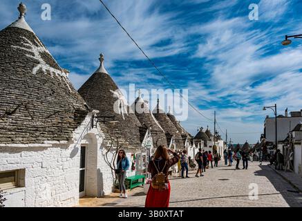 Touriste prenant des photos près de maisons trulli pittoresques à Alberobello, Pouilles Banque D'Images