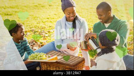 Image de coeurs verts sur panier de pique-nique et famille afro-américaine dans le parc Banque D'Images