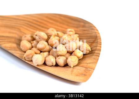 Pois chiches, Cicer arietinum, sur une cuillère en bois Banque D'Images