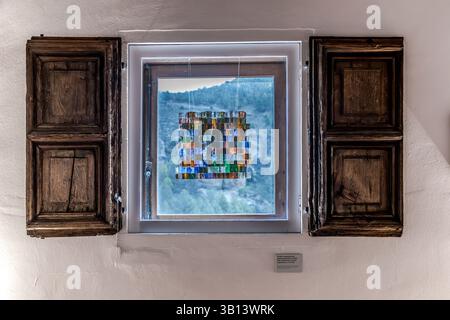 Une mosaïque de vitraux est accrochée dans une fenêtre du Musée d'Art abstrait espagnol (Museo de Arte Abstracto Español). La mosaïque, qui se compose de petits carrés de verre colorés, est exposée dans un cadre de fenêtre en bois. L’œuvre, conçue et réalisée par Rafael Leoz, fait partie d’un module architectural. Calle Obispo Valero, Cuenca, Castille-la Manche, Espagne Banque D'Images