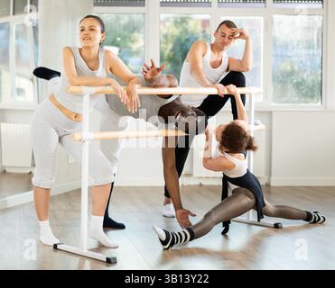 Hommes et femmes communiquent entre eux pendant la pause entre les classes de ballet dans un studio chorégraphique Banque D'Images