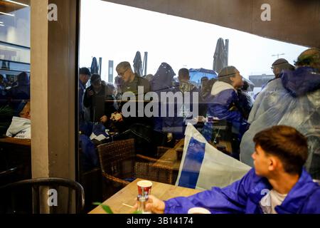 Oswiecim, Pologne. 24 avril 2025. Les participants couverts de drapeaux nationaux israéliens se mettent à l'abri dans un restaurant alors qu'une pluie battante commence pendant la Marche internationale des vivants (MOTL) au Mémorial et musée d'Auschwitz-Birkenau - ancien camp de concentration allemand nazi. MOTL a lieu le jour du souvenir de l'Holocauste, il rassemble des survivants de l'Holocauste, des familles et des partisans. Ils marchent trois kilomètres entre le camp d’Auschwitz et le centre d’extermination de Birkenau en mémoire des victimes de l’holocauste de la première Guerre mondiale (photo Dominika Zarzycka/Sipa USA) crédit : Sipa USA/Alamy Live News Banque D'Images