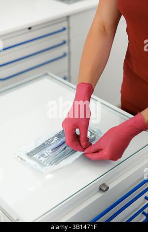Instruments dentaires, aide-dentiste stérilisant, emballage de l'équipement dentiste, poches de stérilisation en plastique, traitement dentaire Banque D'Images