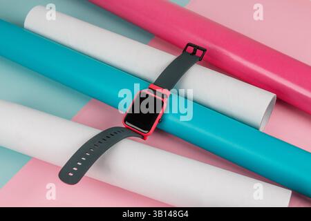 Modèle de montre intelligente numérique sur un fond coloré avec des tubes et un espace de copie Banque D'Images