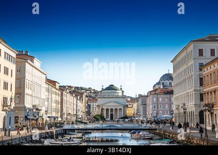 TRIESTE, ITALIE - 17 DÉCEMBRE 2024 : Trieste canal Grande et l'église de Sant Antonio Taumaturgo avec des bateaux, pastel palazzi sur le front de mer. Canal Banque D'Images