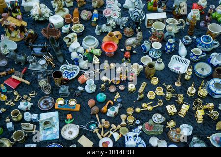 Collection éclectique de bibelots vintage, de céramiques et de curiosités sur une table de marché aux puces à Berlin, capturée d'en haut. Banque D'Images