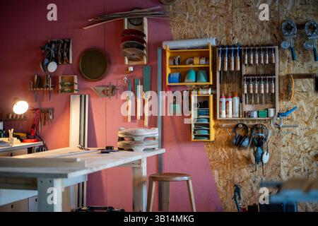 Atelier menuisier professionnel avec armoire à outils et établi pour la création de meubles sur mesure Banque D'Images