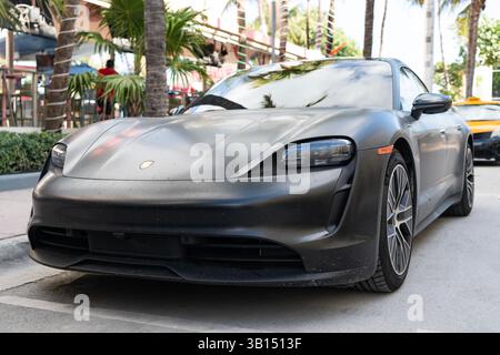 Miami, Floride, États-Unis - 20 décembre 2024 : Porsche Taycan 2023 berline électrique. Berline électrique Porsche Taycan. Voiture noire Porsche Taycan garé Outdoo Banque D'Images