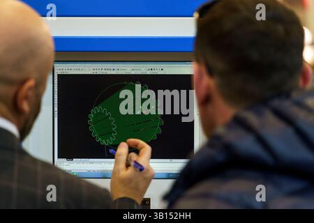 03/11/2025, Russie, novossibirsk, expocentre, exposition de soudure, deux hommes au moniteur discutent des détails, un dessin d'ingénierie, un conver de travail Banque D'Images