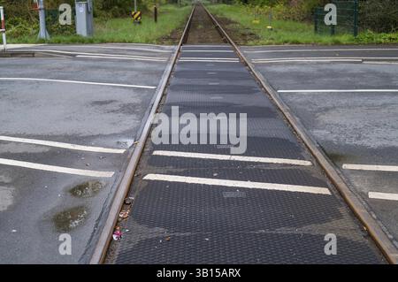 Des voies de tramway recouvertes de caoutchouc traversant une route asphaltée dans une zone urbaine, améliorant la sécurité et réduisant la pollution sonore pour les piétons et les véhicules, Bork Banque D'Images