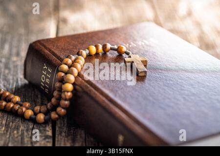 Perles de chapelet en bois et Sainte Bible sur une table en bois. Banque D'Images