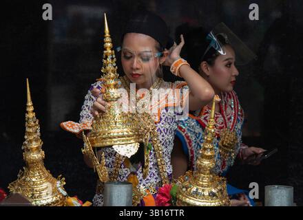 Les danseurs de cérémonie du sanctuaire Erawan de Bangkok portent des visières en plastique pour se protéger contre Covid 19 Banque D'Images