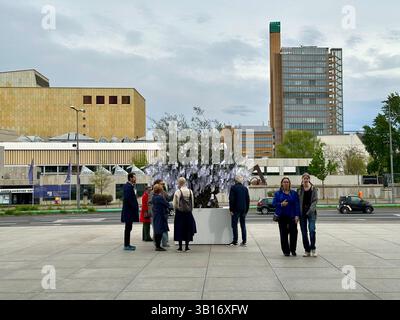 L’installation artistique interactive Wish Tree avec six personnes regardant les étiquettes en papier devant la Neue Nationalgalerie à Berlin, en Allemagne, 2025 Banque D'Images