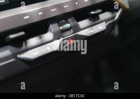 Tableau de bord moderne avec feux de détresse, radio et commandes de climatisation. Design élégant et fonctionnalités conviviales pour une conduite confortable. Banque D'Images