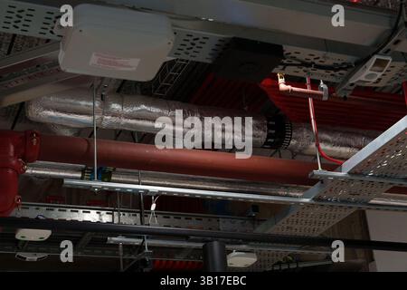 Réseau complexe de tuyaux, fils et systèmes de ventilation installés dans le plafond d'un bâtiment moderne. Banque D'Images