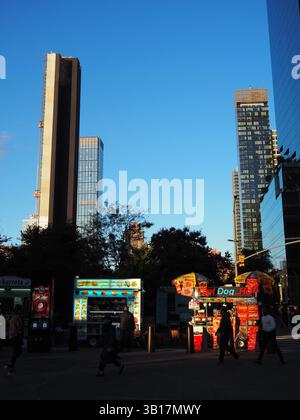 Chariots de nourriture de rue éclairés par le soleil couchant près du navire à New York Banque D'Images